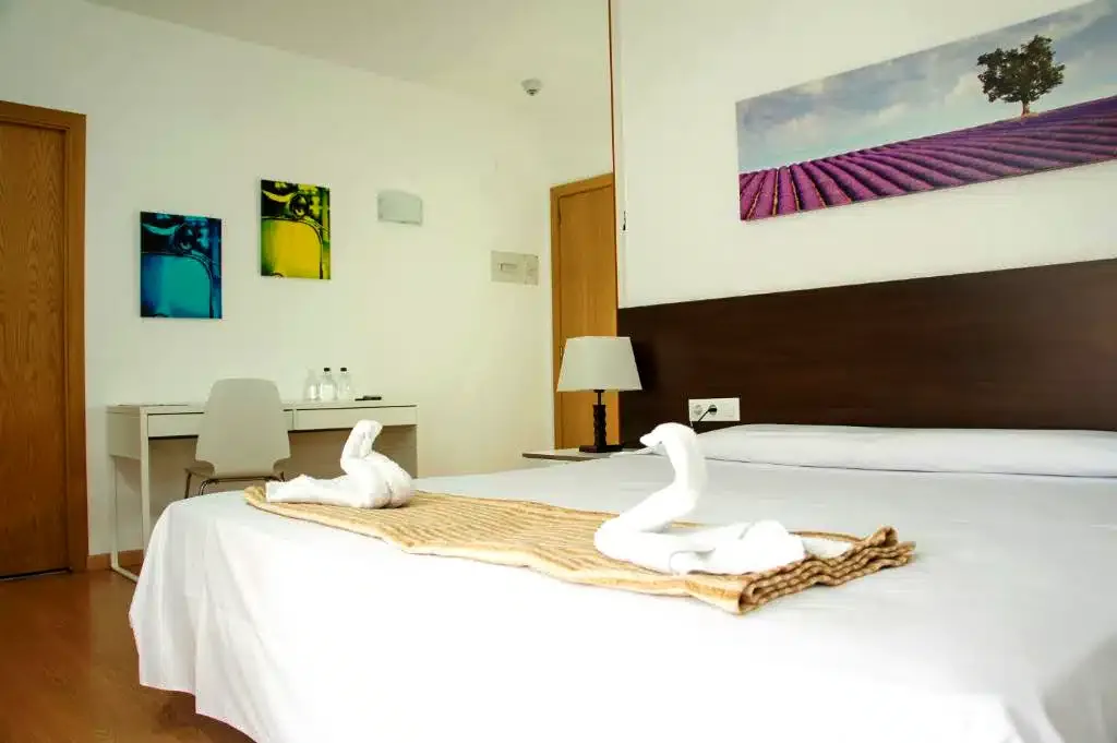 Habitación doble del Adia Hotel con toallas en forma de cisne sobre la cama